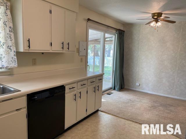 kitchen featuring white cabinets, light countertops, black dishwasher, and a ceiling fan