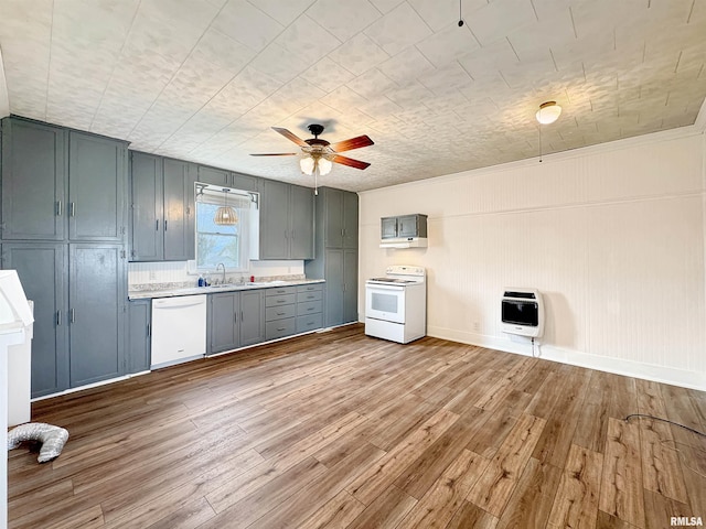 370 W Carter St, Fairview, IL 61432 - kitchen featuring a sink, wood finished floors, heating unit, white appliances, and light countertops