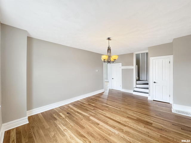370 W Carter St, Fairview, IL 61432 - unfurnished dining area with stairway, baseboards, a notable chandelier, and light wood finished floors