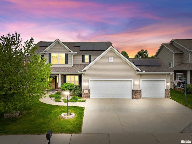 3211 W Saddle Creek Dr, Dunlap, IL 61525 - view of front of home with a front yard, concrete driveway, an attached garage, roof mounted solar panels, and brick siding