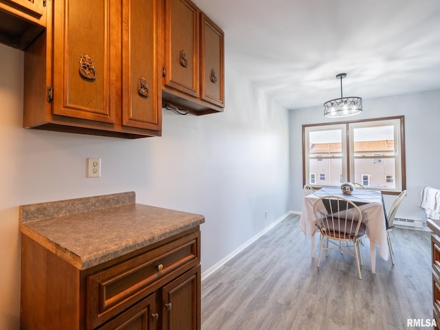 1024 Florence Ave, Pekin, IL 61554 - dining room featuring a baseboard heating unit, light wood-style flooring, a chandelier, and baseboards