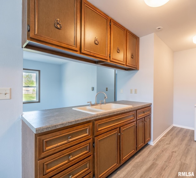 1024 Florence Ave, Pekin, IL 61554 - kitchen featuring a sink, light wood finished floors, brown cabinetry, and baseboards