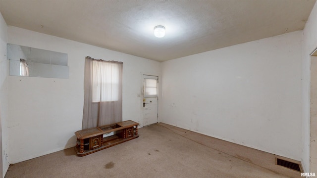 carpeted spare room featuring visible vents