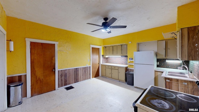 kitchen with light countertops, backsplash, a ceiling fan, a sink, and white appliances