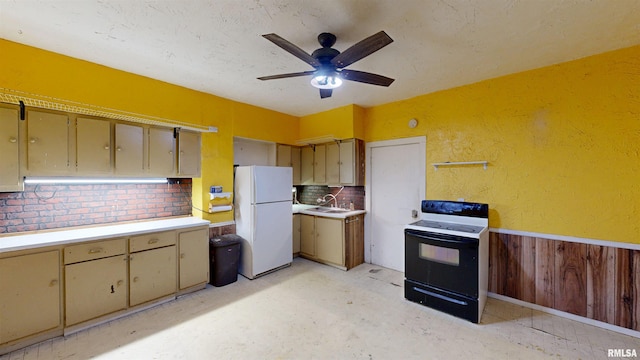 kitchen with electric stove, a sink, ceiling fan, light countertops, and freestanding refrigerator
