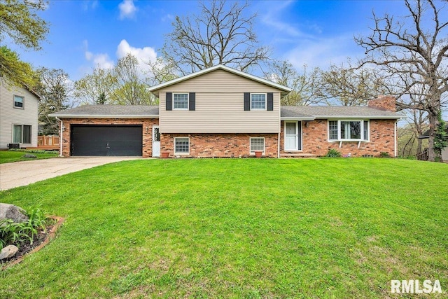 tri-level home featuring a front lawn, concrete driveway, brick siding, and a garage