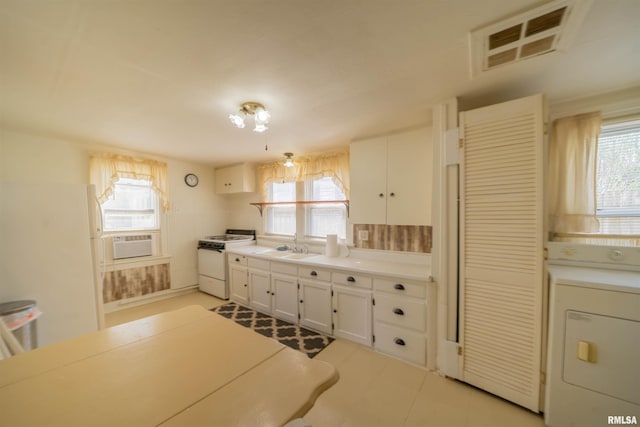 212 S Cone St, Farmington, IL 61531 - kitchen with white cabinets, washer / clothes dryer, light countertops, and white gas range