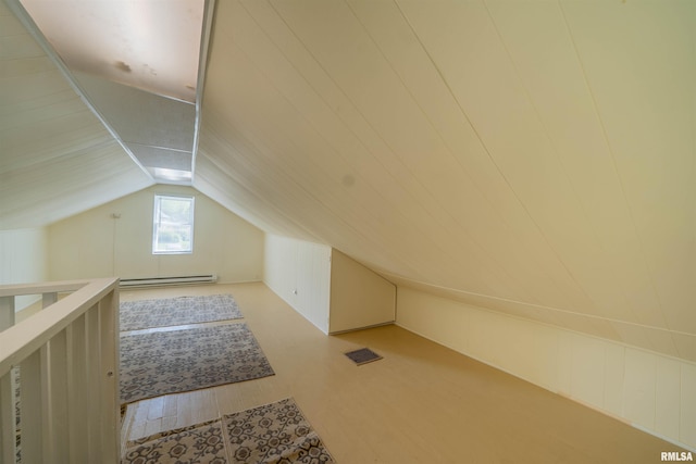 212 S Cone St, Farmington, IL 61531 - additional living space featuring lofted ceiling, wood finished floors, visible vents, and a baseboard heating unit