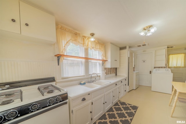 212 S Cone St, Farmington, IL 61531 - kitchen with white cabinetry, a sink, white gas range, visible vents, and washer / dryer
