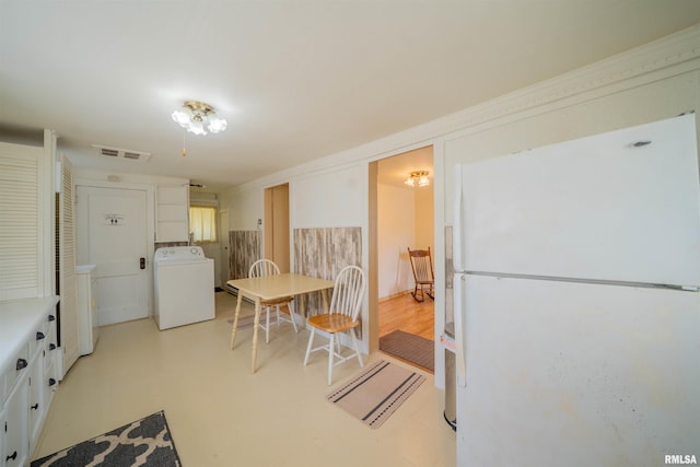 212 S Cone St, Farmington, IL 61531 - kitchen with washer / dryer, visible vents, white cabinetry, freestanding refrigerator, and light floors