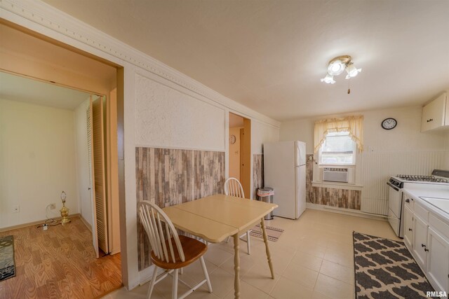 212 S Cone St, Farmington, IL 61531 - kitchen with cooling unit, white cabinets, a wainscoted wall, and white appliances