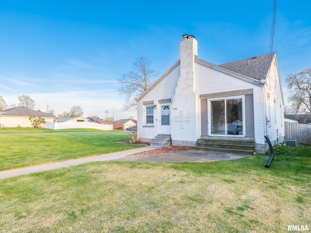 516 E Sciota Ave, Peoria Heights, IL 61616 - back of property with entry steps, brick siding, a chimney, a yard, and a shingled roof