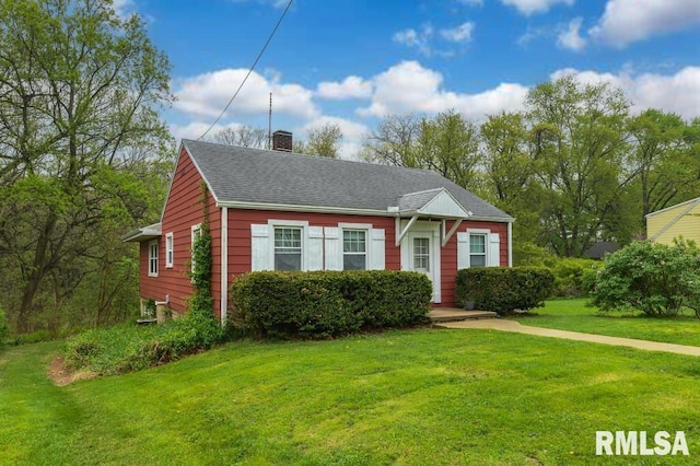 view of front facade with a chimney and a front yard