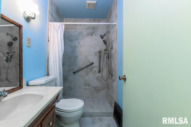 full bath with visible vents, tiled shower, toilet, and vanity