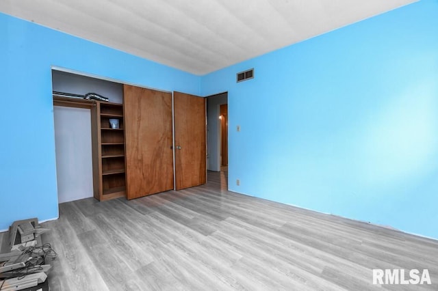 unfurnished bedroom featuring visible vents and light wood-style floors