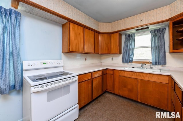 kitchen featuring wallpapered walls, a sink, and white range with electric stovetop