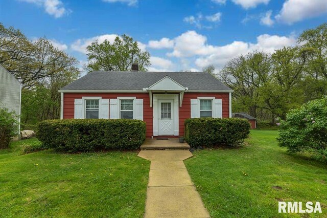 view of front of home with a front lawn and a chimney