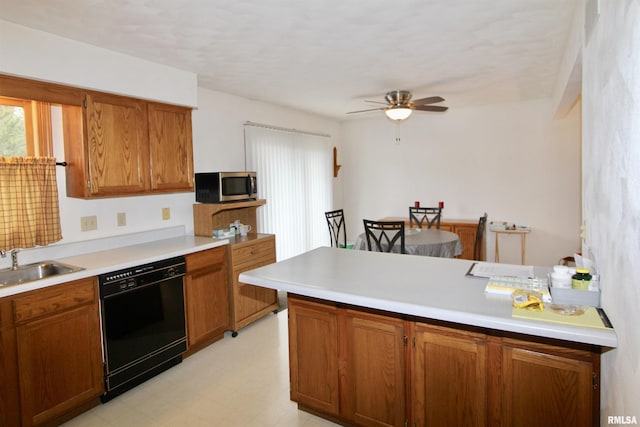 kitchen featuring stainless steel microwave, a sink, black dishwasher, a ceiling fan, and brown cabinetry
