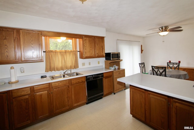 kitchen featuring stainless steel microwave, brown cabinetry, dishwasher, a sink, and a ceiling fan