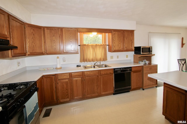 kitchen featuring black appliances, visible vents, brown cabinetry, and a sink