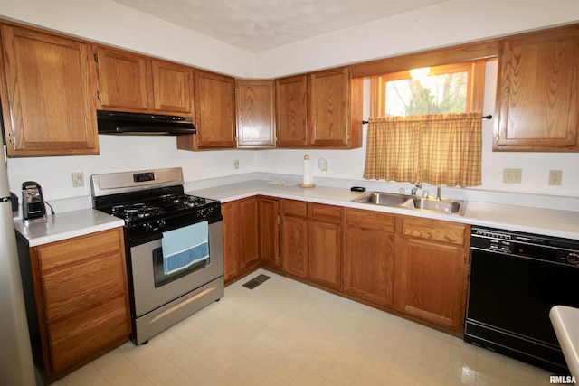 kitchen with stainless steel gas stove, under cabinet range hood, black dishwasher, light countertops, and a sink