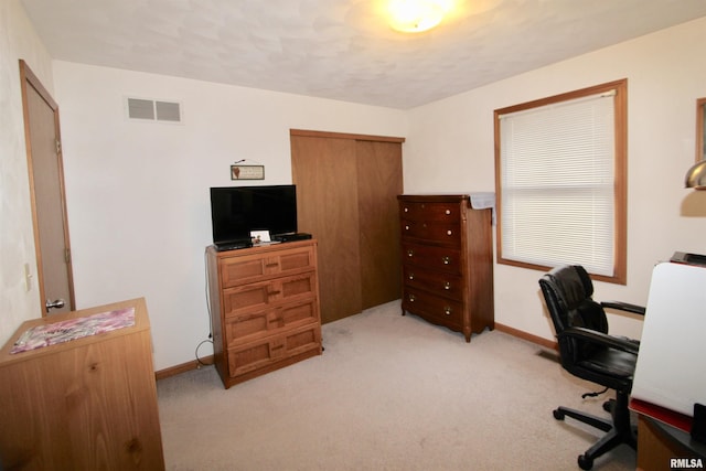 office with baseboards, visible vents, and light colored carpet