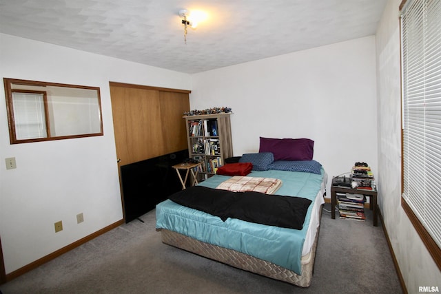 bedroom with baseboards, a closet, and carpet flooring