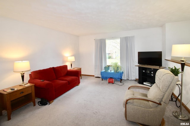 carpeted living area with baseboards