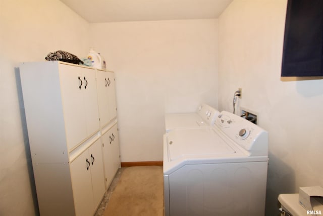 clothes washing area with light colored carpet, baseboards, cabinet space, and washing machine and dryer