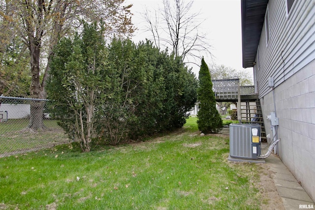 view of yard with fence, cooling unit, and stairs