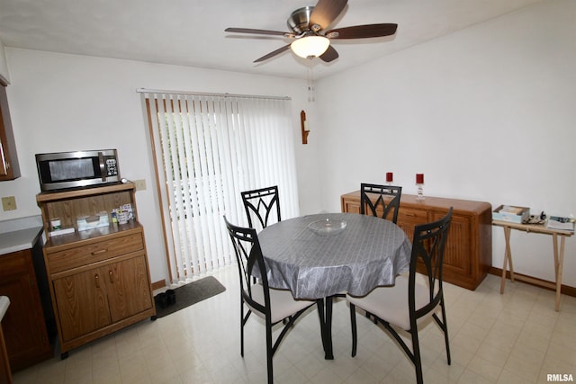dining area with baseboards, light floors, and ceiling fan