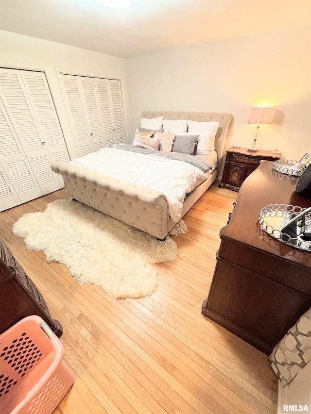 bedroom featuring light wood-style floors and two closets