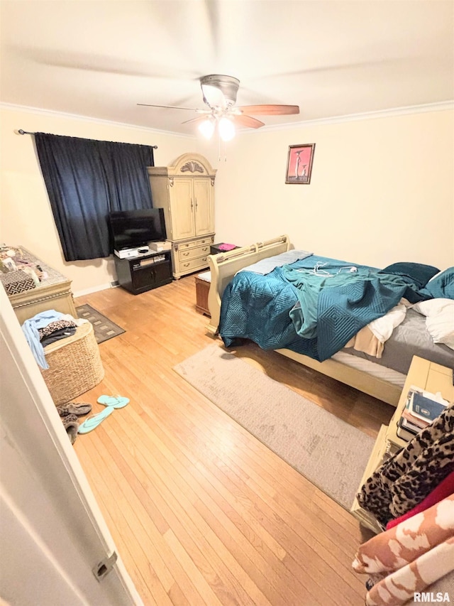 bedroom featuring ornamental molding, ceiling fan, and light wood-style floors
