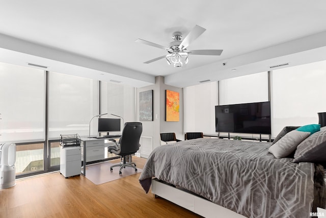 bedroom with light wood-style floors, a ceiling fan, and visible vents