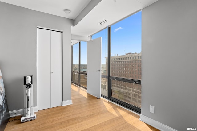 interior space with visible vents, baseboards, wood finished floors, and a closet