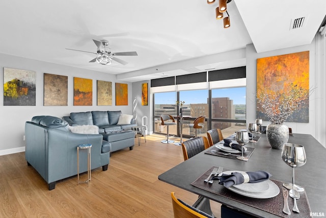living area featuring baseboards, ceiling fan, visible vents, and wood finished floors