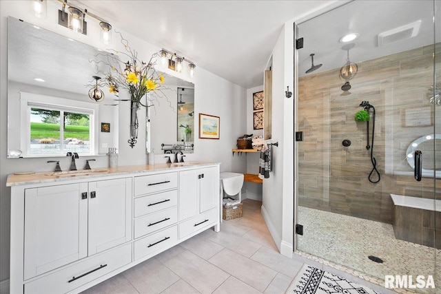 bathroom featuring a sink, tile patterned floors, baseboards, and a shower stall