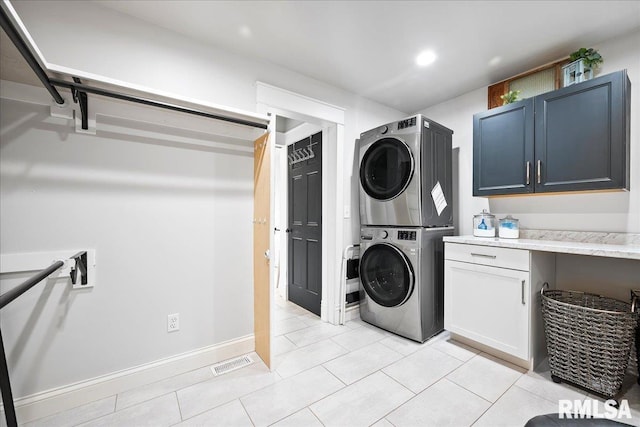 laundry area featuring cabinet space, stacked washer / drying machine, recessed lighting, light tile patterned floors, and visible vents