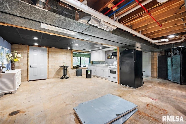 below grade area featuring a sink and freestanding refrigerator