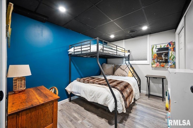 bedroom with a paneled ceiling, recessed lighting, baseboards, and wood finished floors