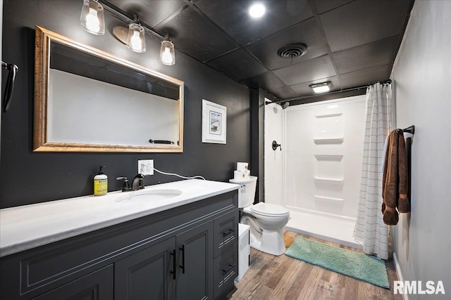 full bathroom with vanity, a shower with shower curtain, wood finished floors, and toilet