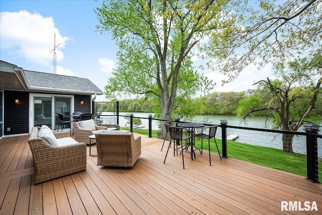deck featuring outdoor dining area, a water view, outdoor lounge area, and a yard