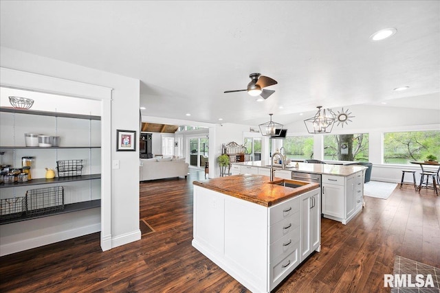kitchen featuring open floor plan, a sink, a center island with sink, and dark wood-style floors