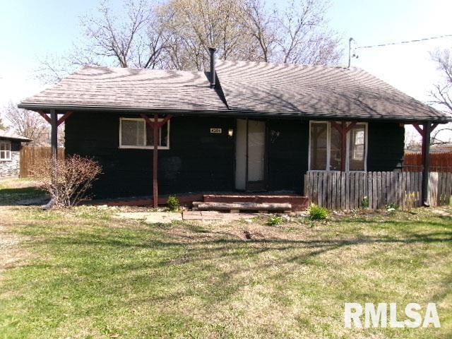 ranch-style house with fence, a front yard, and a shingled roof
