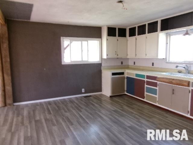 kitchen featuring a wealth of natural light, light countertops, dark wood finished floors, and a sink