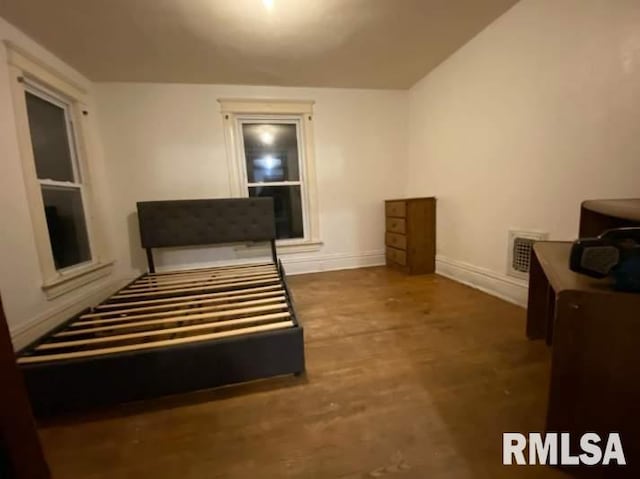 bedroom featuring baseboards, visible vents, and wood finished floors