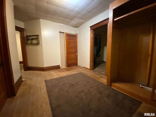 hallway featuring baseboards and light wood finished floors