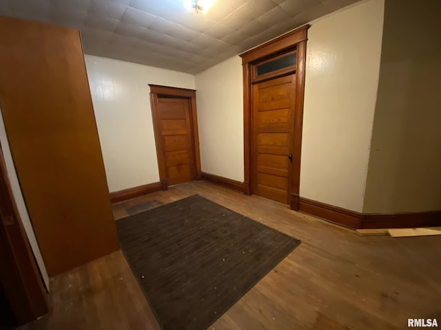 corridor featuring baseboards and wood finished floors