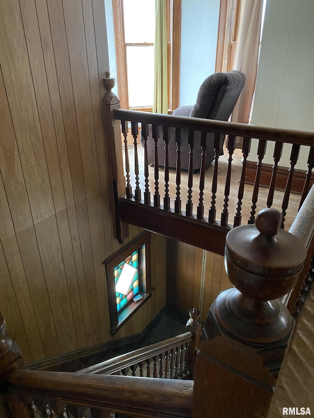 stairs featuring wood walls