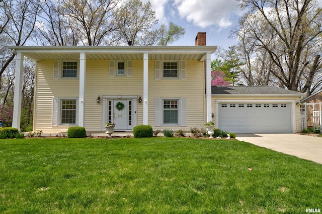 greek revival inspired property with concrete driveway, a front yard, an attached garage, and a chimney